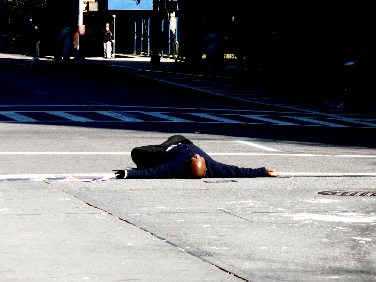 1 of 3 Man lays down in middle of 5th avenue as the leaders of the NYC Marathon approach.